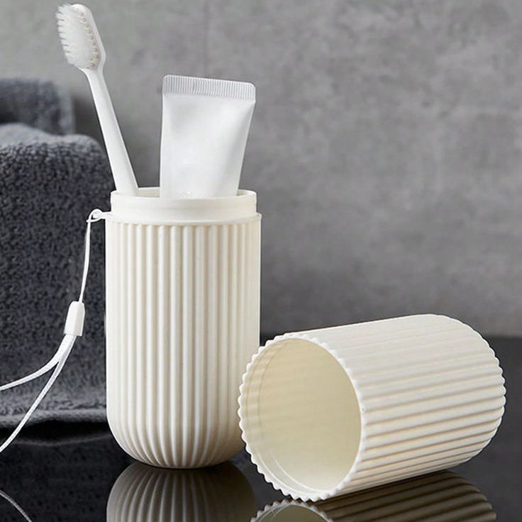 White ribbed toothbrush holder with toothbrush and tube on a dark surface