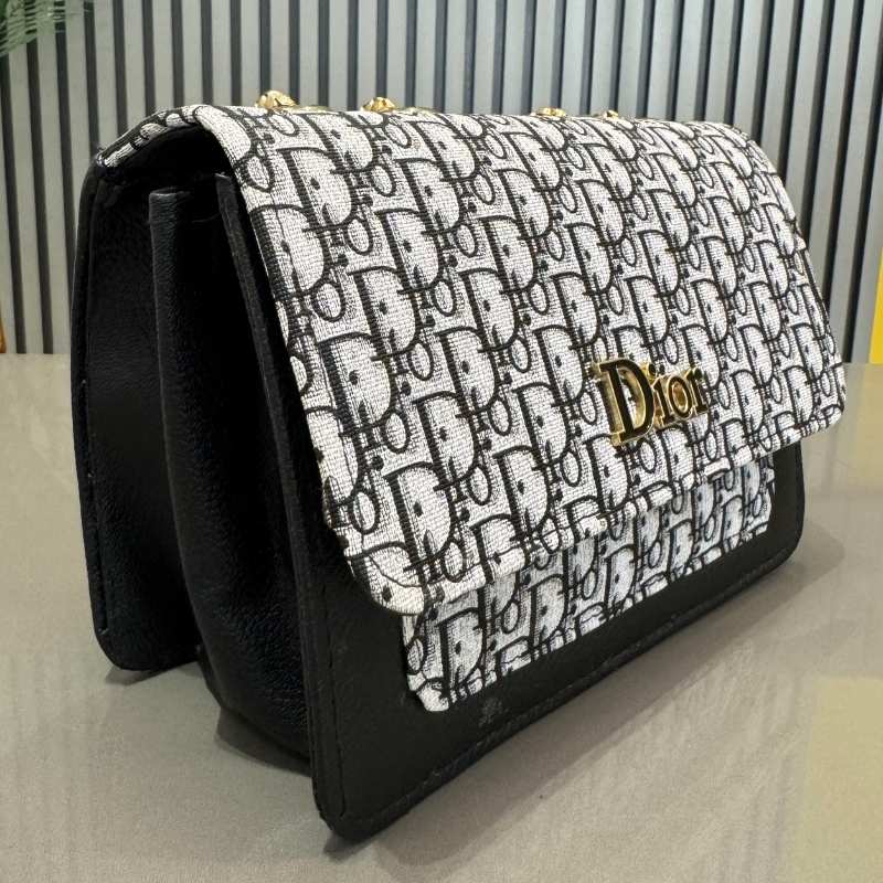 Black and white patterned handbag with 'Dior' logo on a light surface.