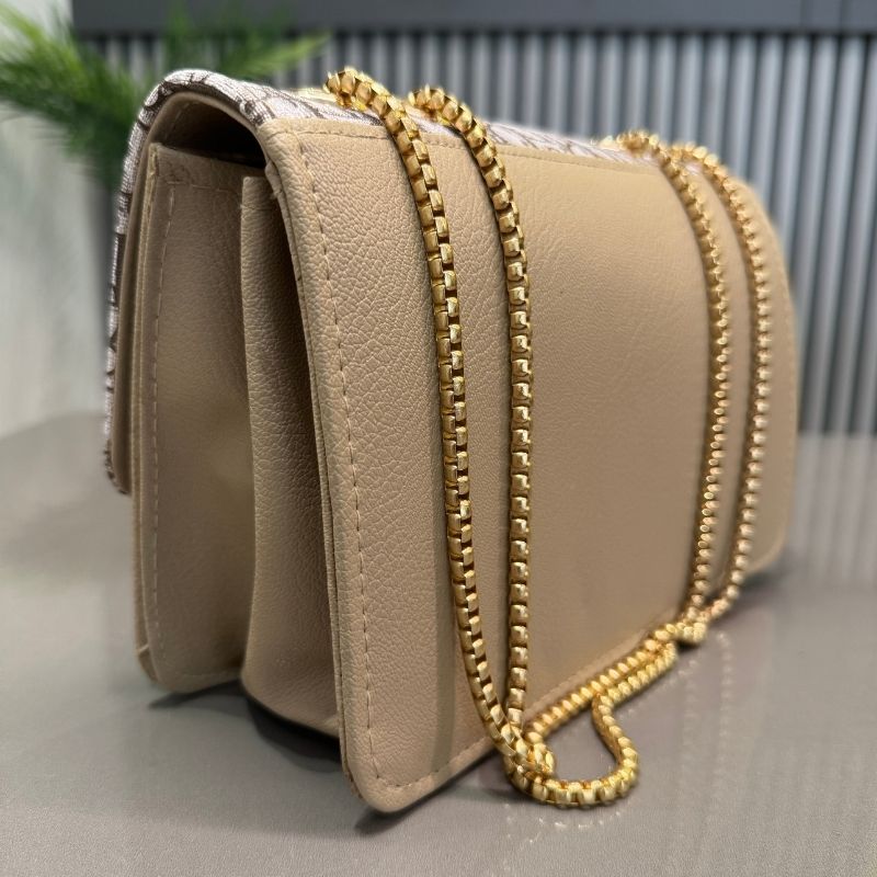 Beige handbag with gold chain strap on a neutral background