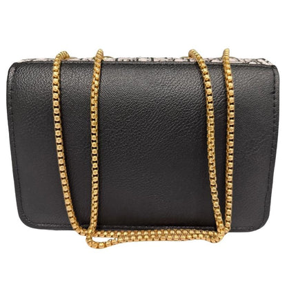 Black handbag with a gold chain strap on a white background