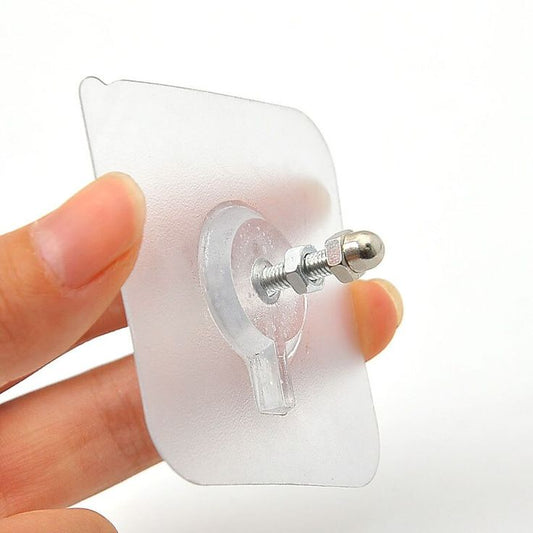Clear plastic earring with a metal backing held between fingers on a white background